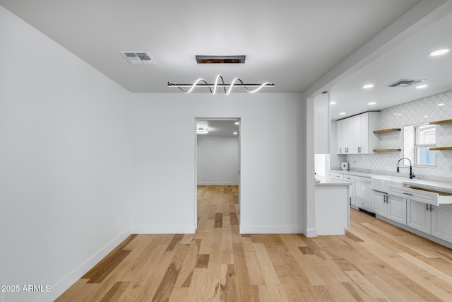 kitchen with visible vents, light countertops, decorative backsplash, and dishwasher