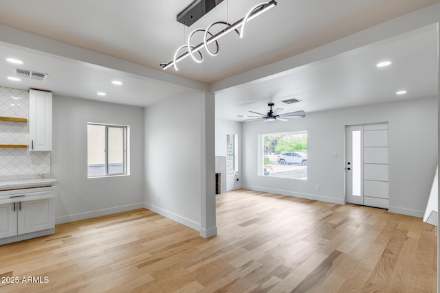 unfurnished living room with light wood-style floors, recessed lighting, visible vents, and baseboards