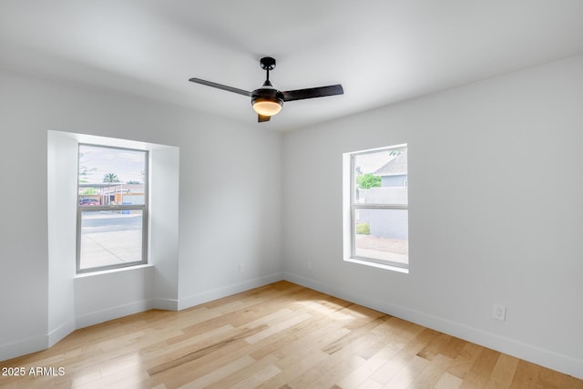 empty room with light wood-style flooring, ceiling fan, and baseboards