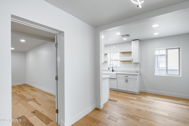 interior space featuring visible vents, baseboards, and light wood finished floors