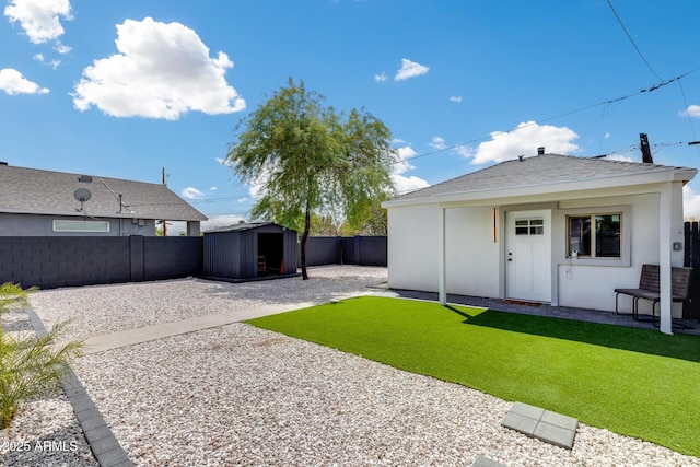 view of yard featuring a patio area, a fenced backyard, a shed, and an outdoor structure