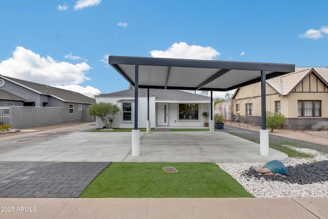 exterior space featuring a carport, driveway, and fence