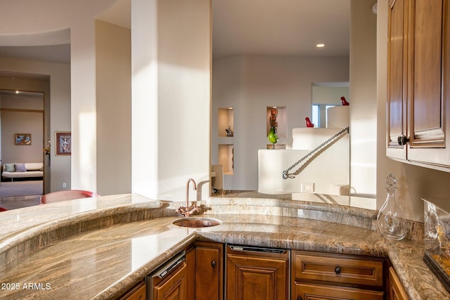 kitchen with sink, light stone countertops, and kitchen peninsula