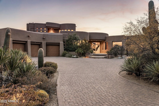 pueblo revival-style home featuring a garage