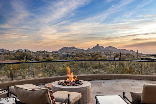 patio terrace at dusk featuring a mountain view and an outdoor fire pit