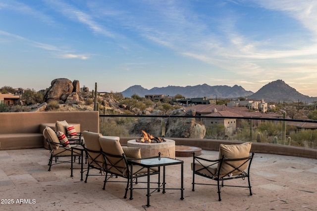 view of patio with a mountain view and a fire pit