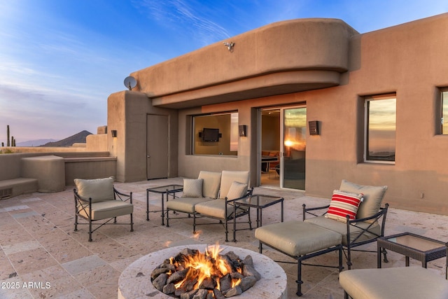 patio terrace at dusk featuring an outdoor fire pit