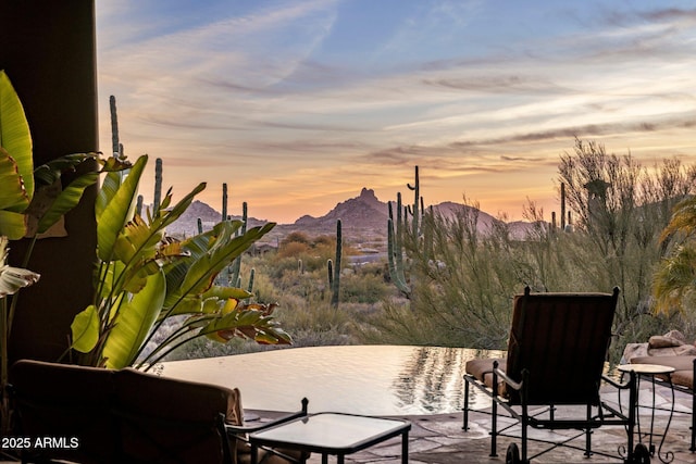 patio terrace at dusk with a water and mountain view