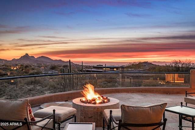 patio terrace at dusk with a mountain view and a fire pit