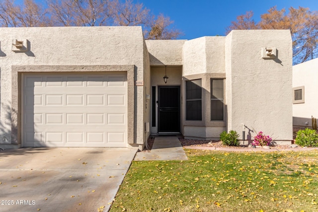 pueblo revival-style home with a front yard and a garage