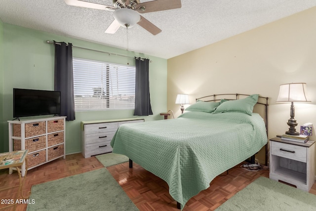 bedroom featuring ceiling fan, a textured ceiling, and dark parquet flooring