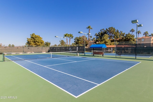 view of tennis court featuring basketball hoop