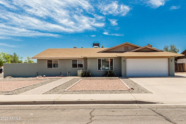 single story home featuring fence, a garage, driveway, and stucco siding