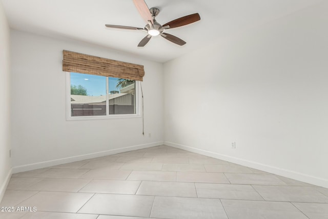spare room featuring baseboards, a ceiling fan, and light tile patterned floors
