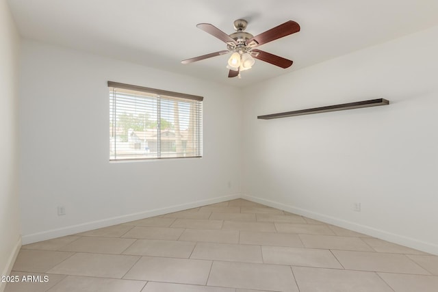 empty room with baseboards, a ceiling fan, and light tile patterned floors