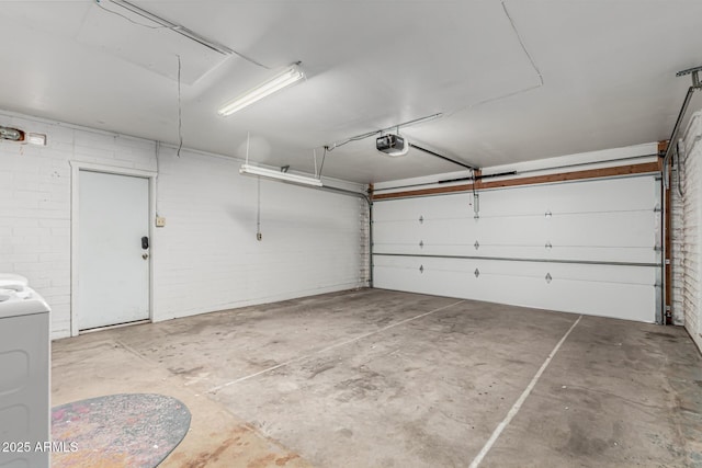 garage featuring a garage door opener and washer / dryer