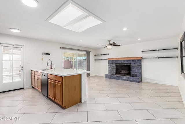 kitchen featuring recessed lighting, light countertops, brown cabinets, a sink, and a skylight