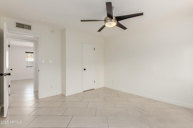 spare room featuring light tile patterned floors, baseboards, ceiling fan, and visible vents