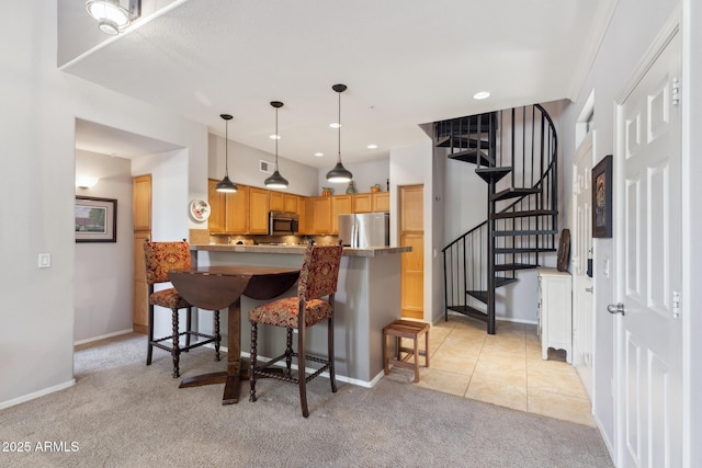 20100 N 78th Pl Unit 2193, Scottsdale, AZ 85255 - kitchen with stainless steel appliances, light carpet, a peninsula, a breakfast bar, and pendant lighting