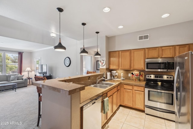 20100 N 78th Pl Unit 2193, Scottsdale, AZ 85255 - kitchen with stainless steel appliances, open floor plan, a peninsula, decorative backsplash, and hanging light fixtures