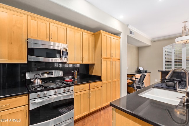 kitchen with appliances with stainless steel finishes, ornamental molding, decorative backsplash, and sink