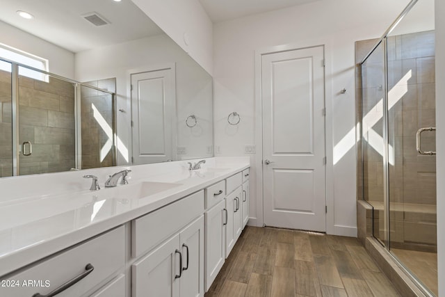 bathroom with walk in shower, wood-type flooring, and vanity