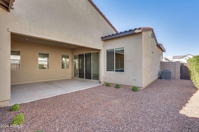 rear view of property featuring cooling unit and a patio area