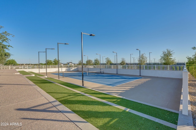 view of tennis court with a yard