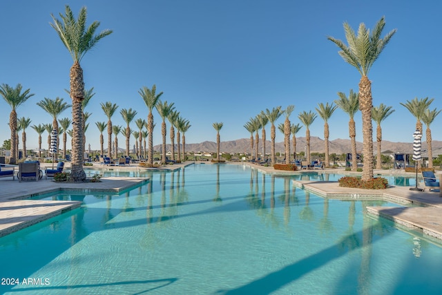 view of swimming pool with a mountain view and a patio area