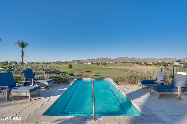 view of swimming pool with a mountain view and a patio area