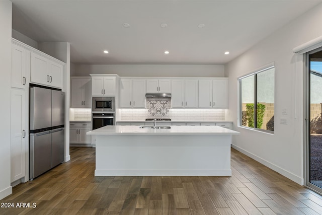 kitchen featuring an island with sink, stainless steel appliances, dark hardwood / wood-style floors, and white cabinetry