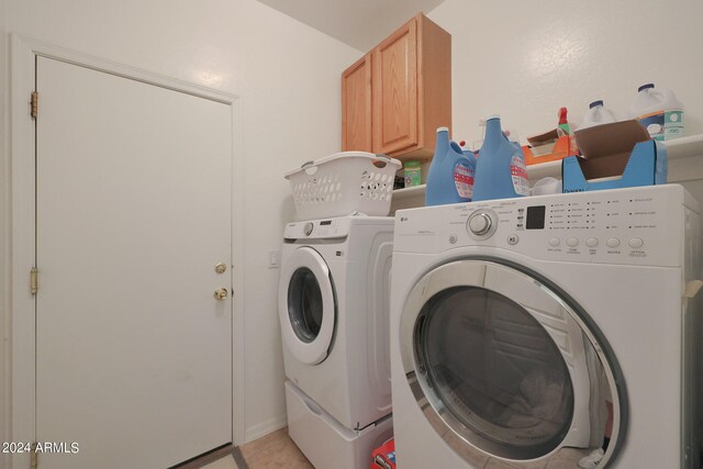 laundry area featuring cabinets, light tile patterned floors, and separate washer and dryer