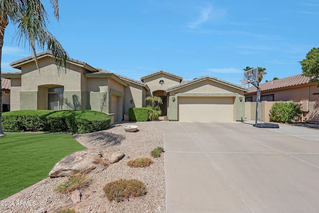 mediterranean / spanish-style home with a garage and a front lawn