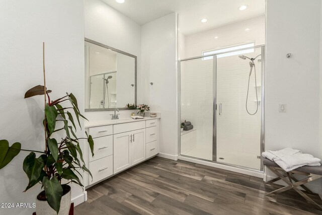 bathroom featuring vanity, wood-type flooring, and a shower with shower door