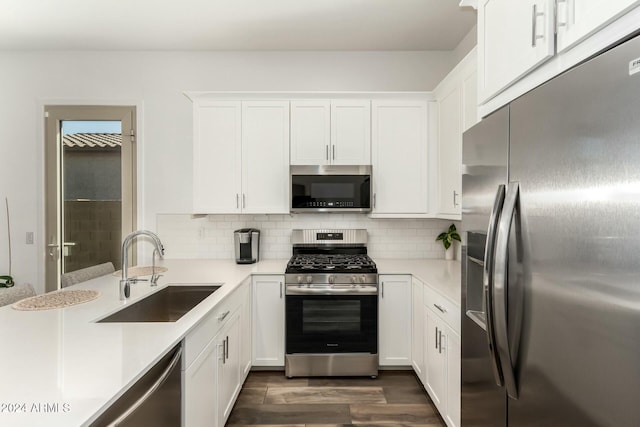 kitchen featuring white cabinets, sink, stainless steel appliances, and tasteful backsplash