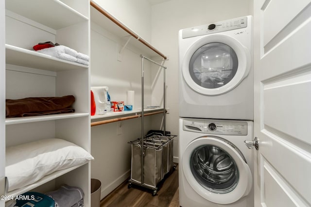 laundry room featuring stacked washer / drying machine and dark wood-type flooring