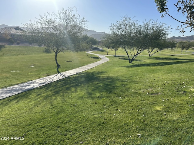 view of home's community with a mountain view and a yard