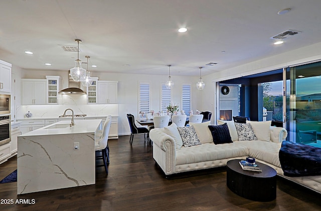 living room featuring sink and dark hardwood / wood-style flooring