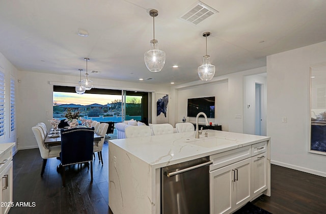 kitchen with sink, white cabinetry, stainless steel dishwasher, an island with sink, and pendant lighting