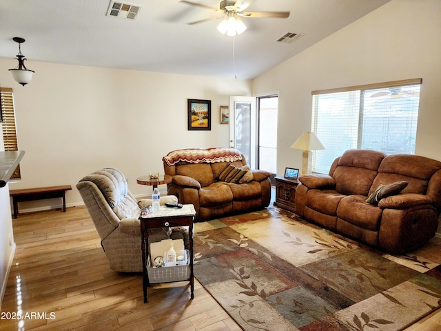 living room with ceiling fan, lofted ceiling, and light wood-type flooring