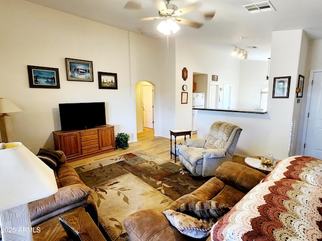 living room with light hardwood / wood-style flooring, ceiling fan, and track lighting