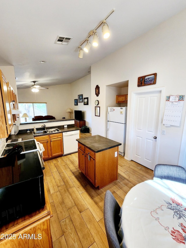 kitchen featuring sink, white appliances, a center island, light hardwood / wood-style floors, and kitchen peninsula