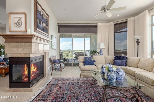 carpeted living area with a ceiling fan, a tiled fireplace, and recessed lighting