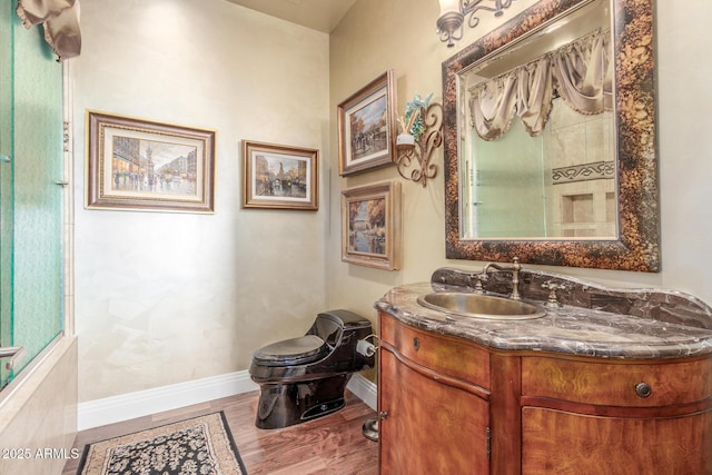 bathroom featuring toilet, baseboards, and vanity