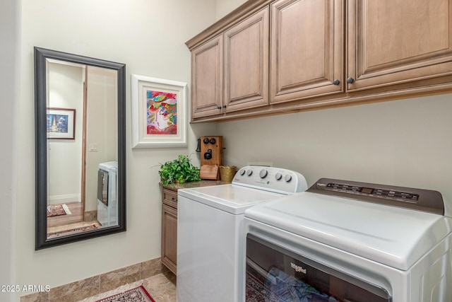 washroom with cabinet space, baseboards, and independent washer and dryer