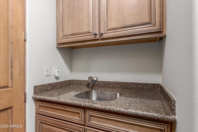 kitchen featuring dark stone counters and a sink