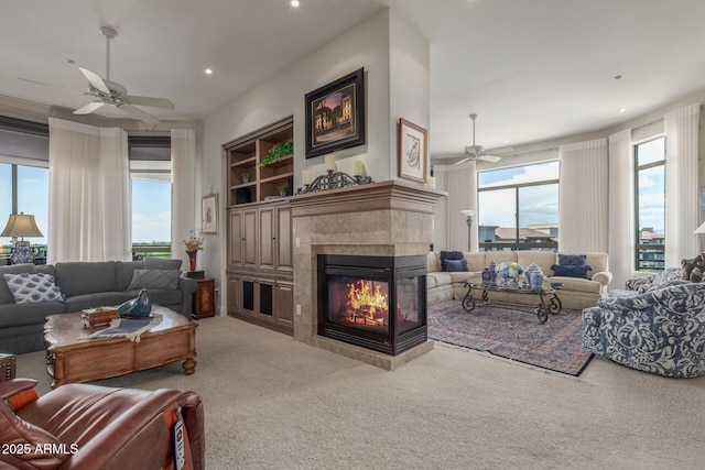 living room featuring a wealth of natural light, ceiling fan, and carpet floors