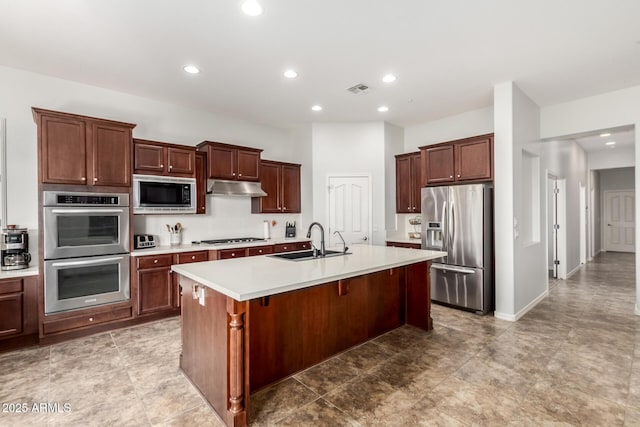 kitchen featuring sink, a kitchen bar, stainless steel appliances, and an island with sink