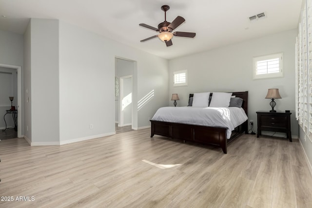 bedroom with multiple windows, ceiling fan, and light hardwood / wood-style floors