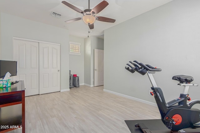 workout area with ceiling fan and light hardwood / wood-style floors